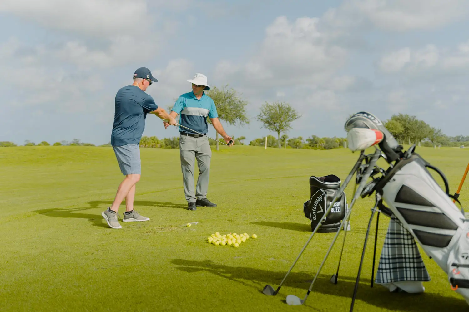 Two men are playing golf on a green.