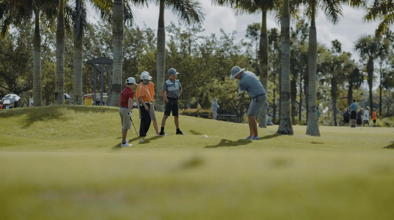 A group of people playing golf on the green.