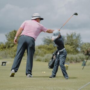 A man and boy playing golf on the green.