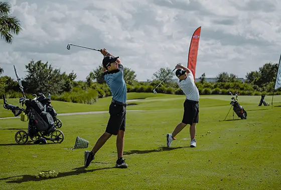 Two men are playing golf on a green.