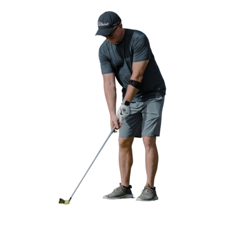 A man in grey shirt and shorts playing golf.